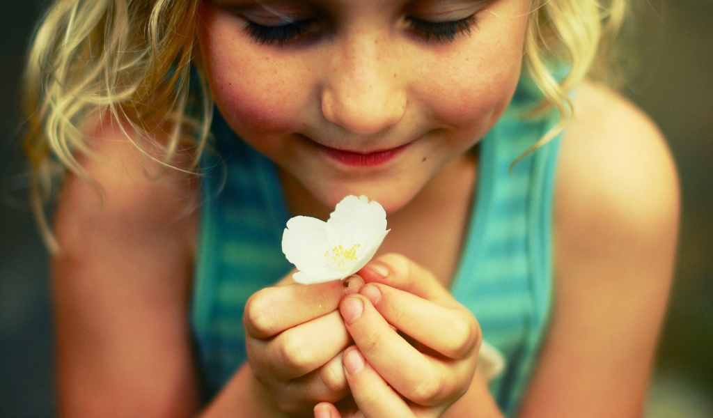 Маленькая девочка  держит белый цветок 