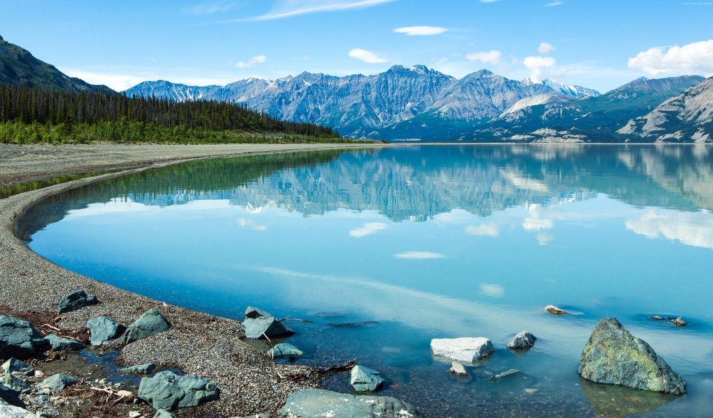 Горы отражаются в голубой воде озера Клуэйн, Национальный парк на территории Юкон, Канада.