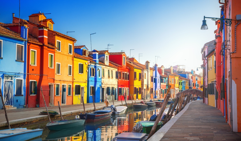 Multi-colored houses by the water channel with boats, Italy