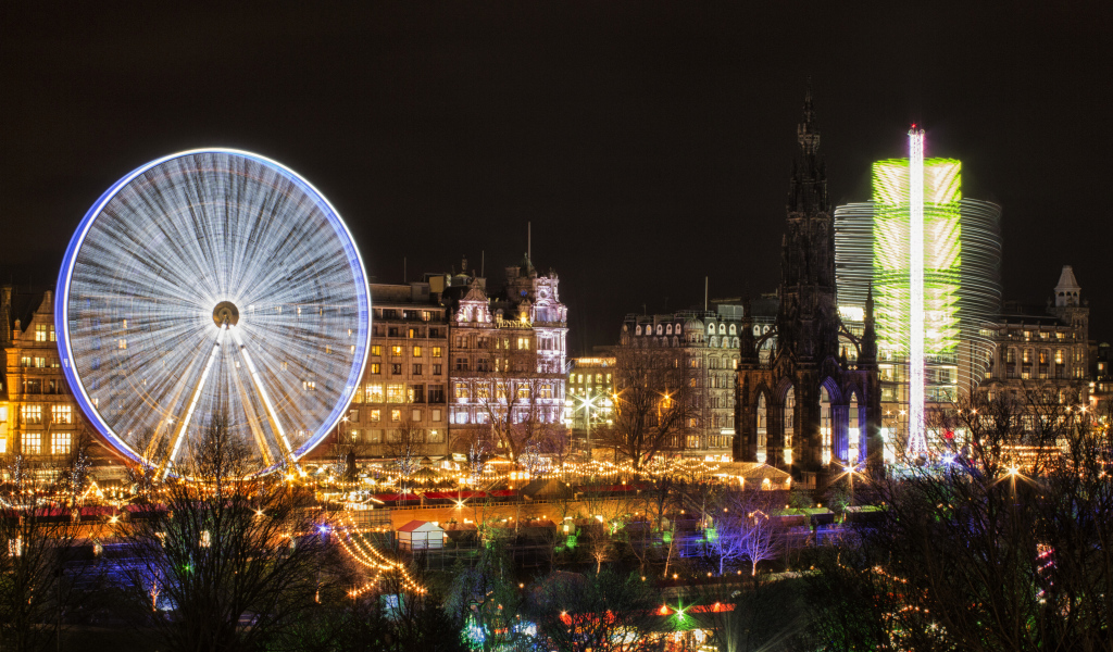 Ferris wheel in the evening against the background of the city of Edinburgh, Scotland