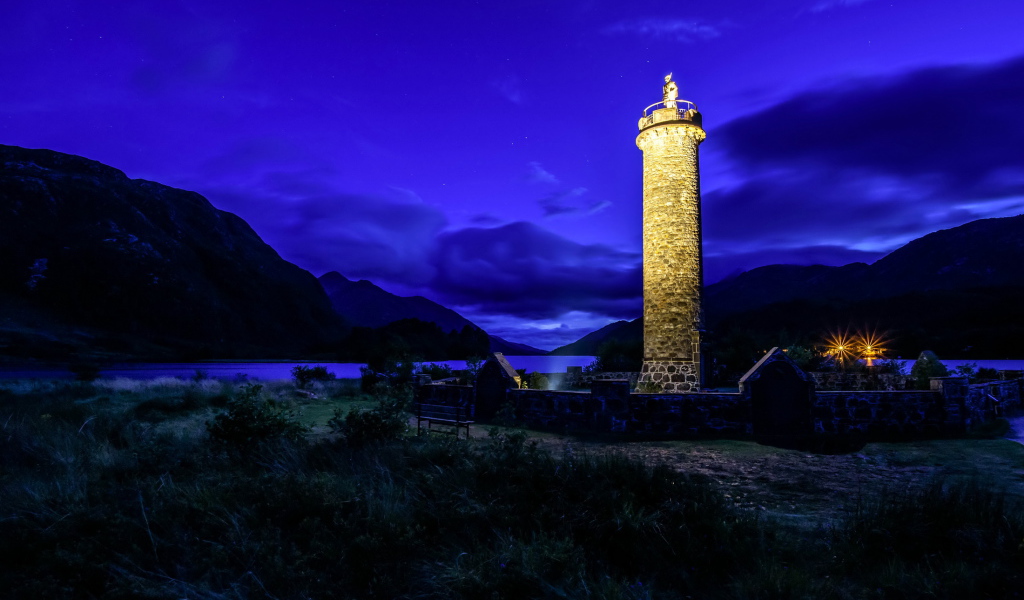 Ночной маяк у побережья на фоне гор, деревня Гленфиннан. Шотландия
