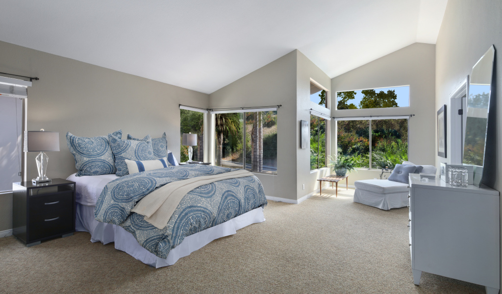 Уютная спальная комната в серых тонах с большими окнами