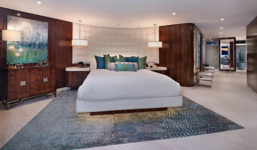 Большая кровать с белым покрывалом в спальне в коричневых тонах