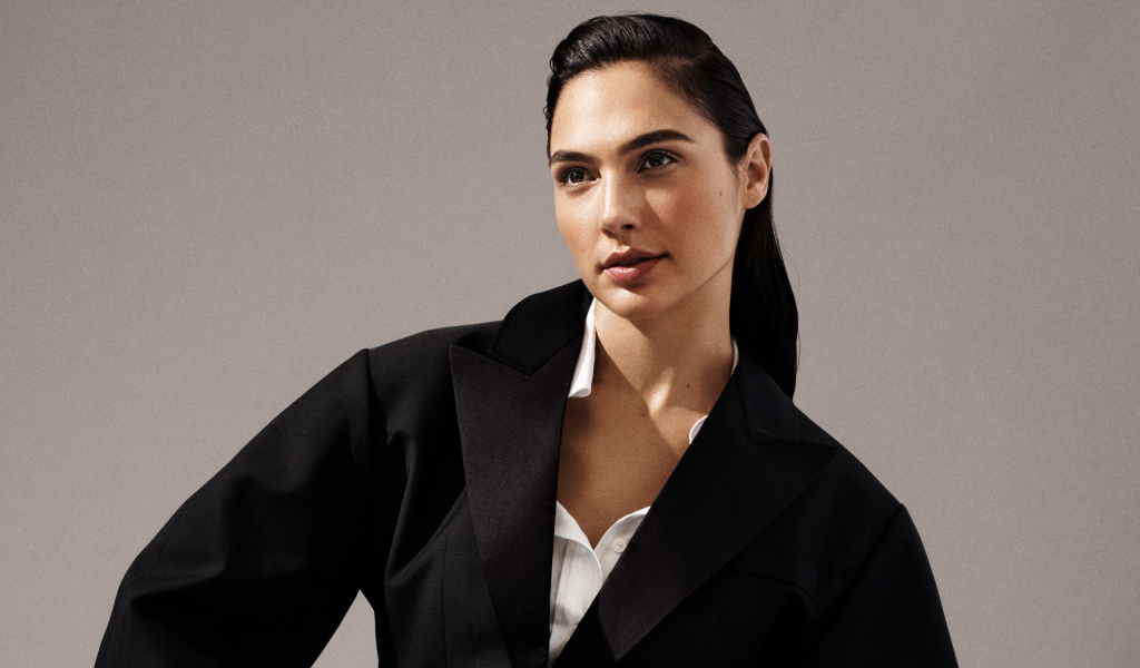 Актриса Галь Гадот в черном пальто на сером фоне