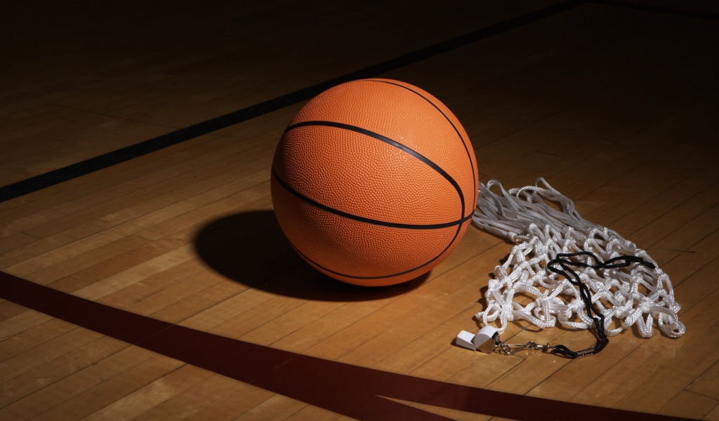 Баскетбольный мяч, свисток  и сетка на полу в спортзале 