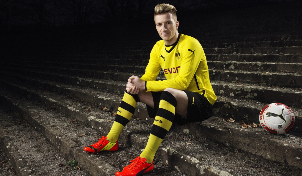 Немецкий футболист Марко Ройс сидит на ступеньках 