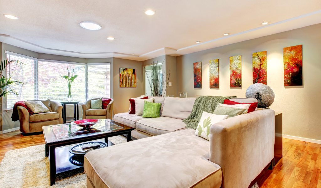 Большой диван в интерьере гостинной в пастельных тонах