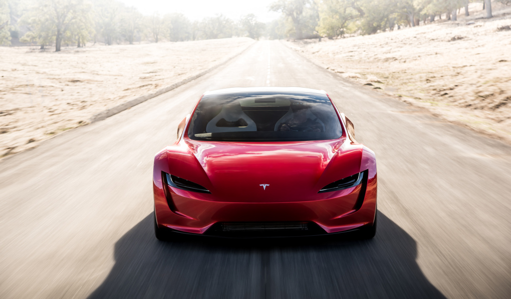 Красный автомобиль Tesla Roadster на трассе, вид спереди