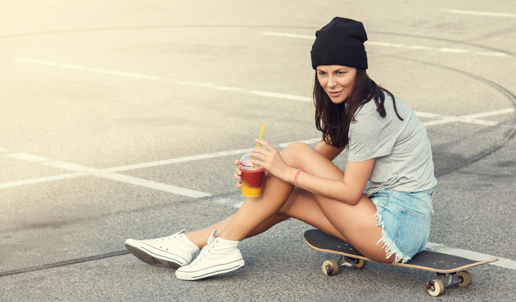 Sporty girl sitting on a skateboard