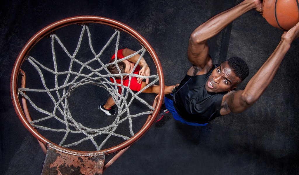 Баскетболист забрасывает мяч в кольцо 