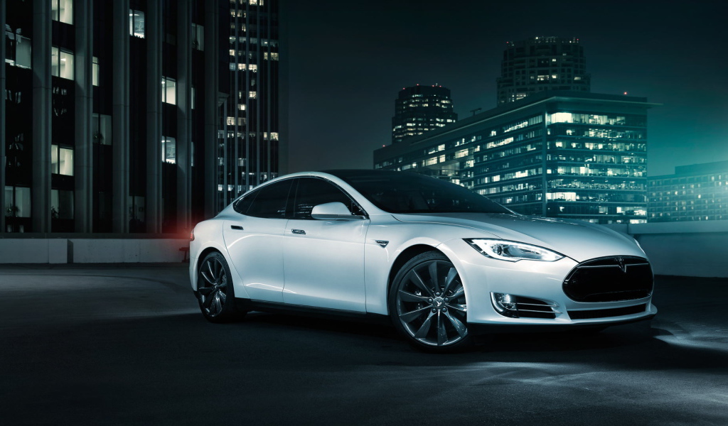 Белый электромобиль Тесла на фоне города 