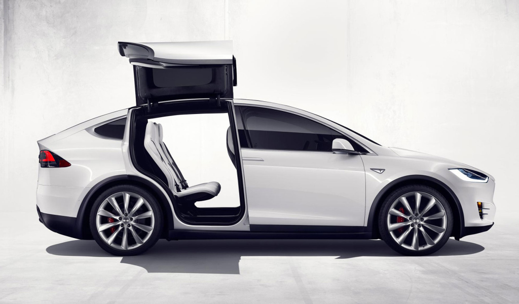 Белый электромобиль Тесла с открытыми дверями  