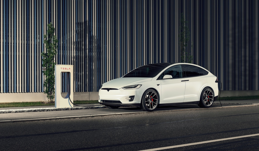 Белый электрокар Tesla Model X на заправке