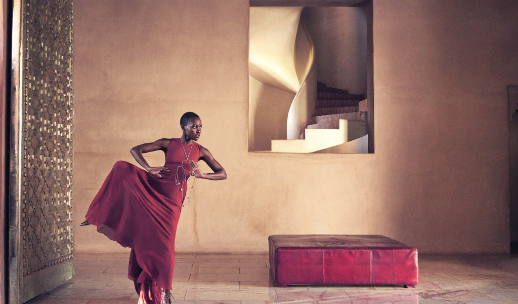 Молодая актриса Люпита Нионго танцует в красном платье