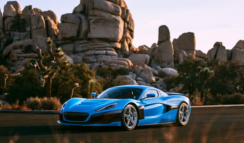 Голубой спортивный автомобиль  Rimac C_Two на фоне гор