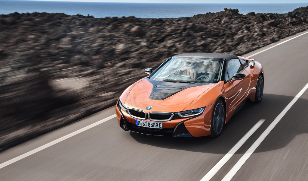 Оранжевый автомобиль BMW i8 Roadster, 2018 на скорости