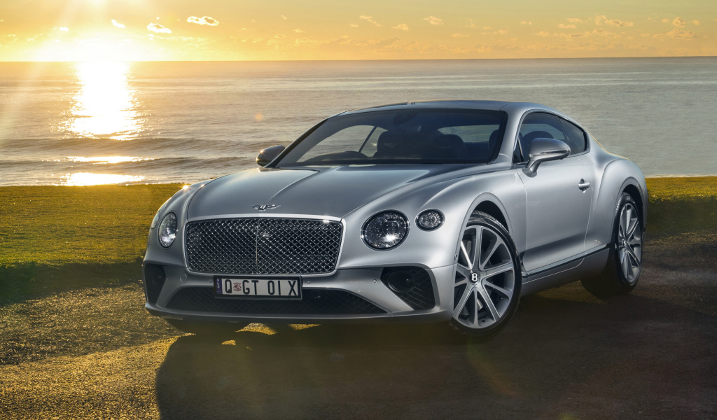 Серебристый Bentley Continental GT 2018 года на фоне моря