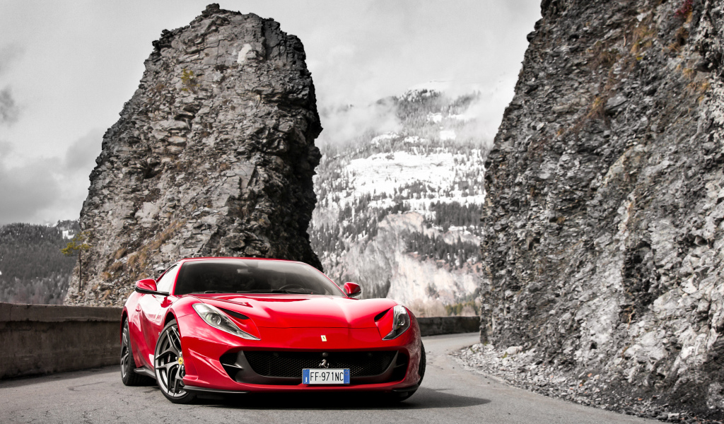 Красный спортивный автомобиль Ferrari Portofino 2018 года на фоне гор