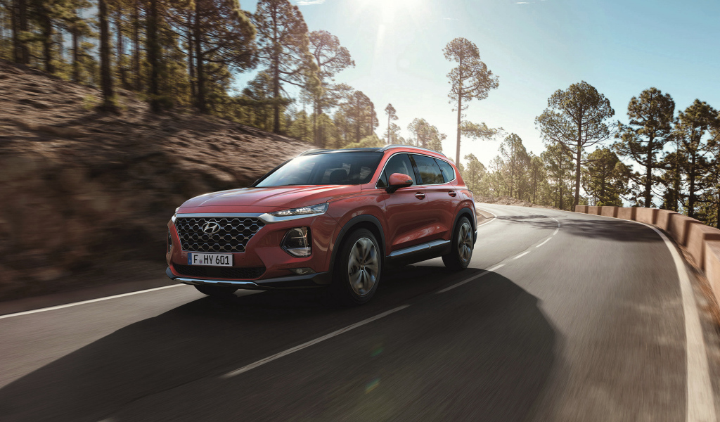 Красный автомобиль Hyundai Santa Fe, 2018 года на трассе