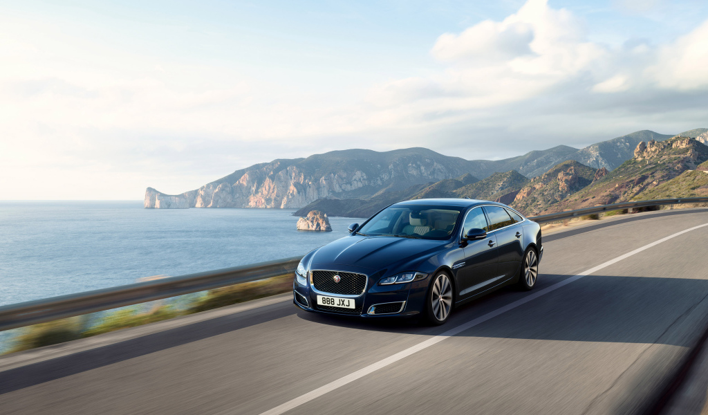 Черный автомобиль Jaguar XJ50, 2018 года на трассе