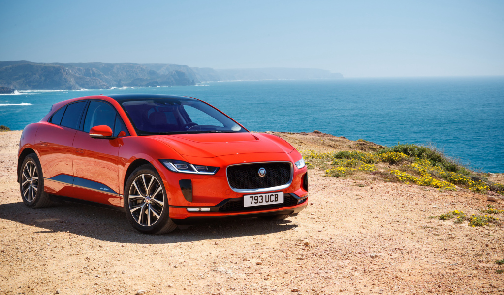 Красный Jaguar I-Pace EV400 AWD HSE First Edition 2018 года на фоне океана 