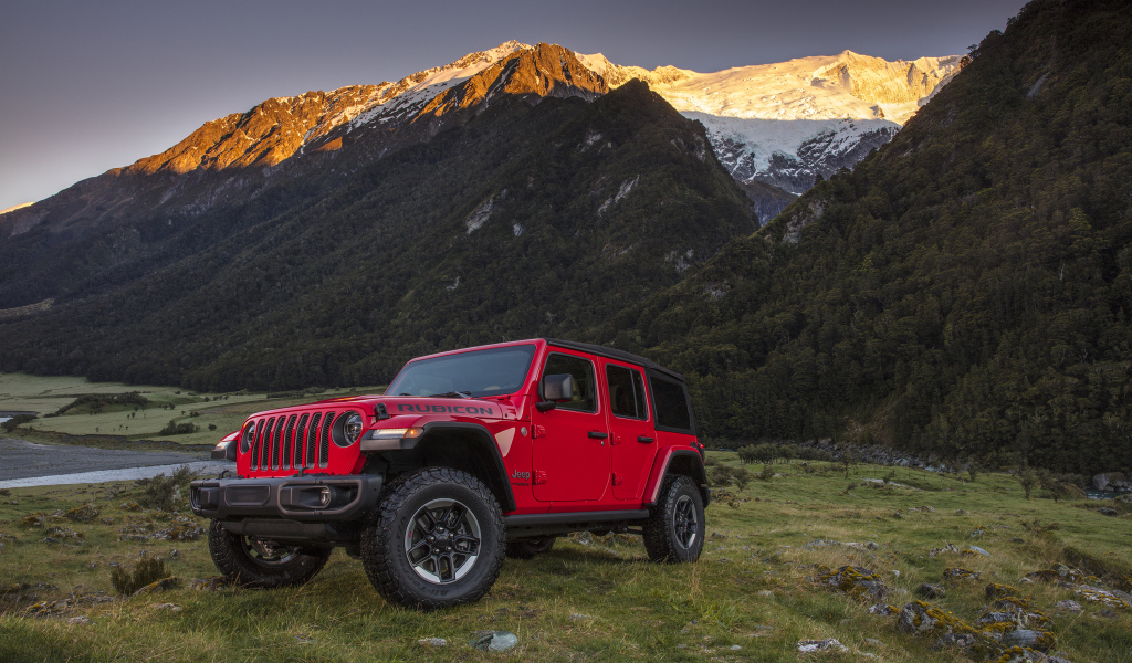 Красный автомобиль Jeep Wrangler на фоне гор