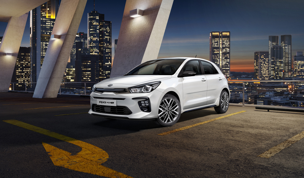 White car hatchback Kia Rio GT Line, 2018 on a background of a night city