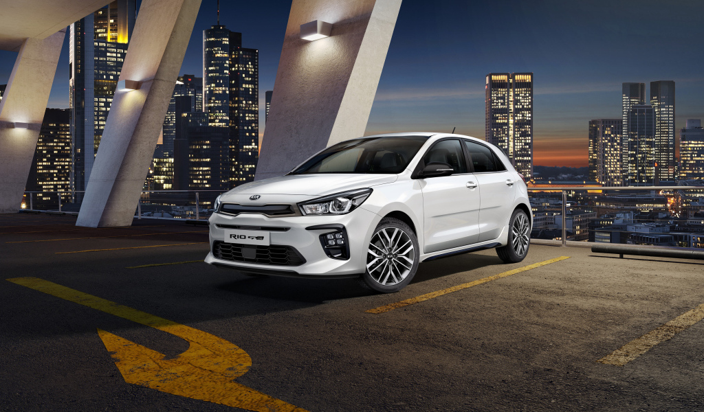 Белый автомобиль хэтчбек Kia Rio GT Line, 2018 на фоне ночного города