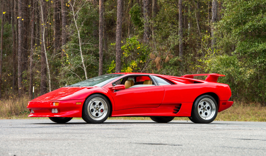Красный спортивный автомобиль Lamborghini Diablo на фоне леса