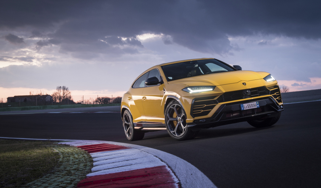 Желтый внедорожник Lamborghini Urus  едет по дороге