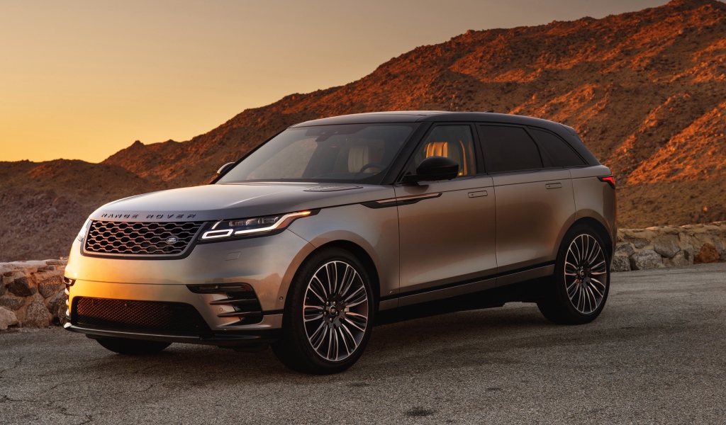 Серебристый внедорожник Land Rover 2018 года на фоне скалы 