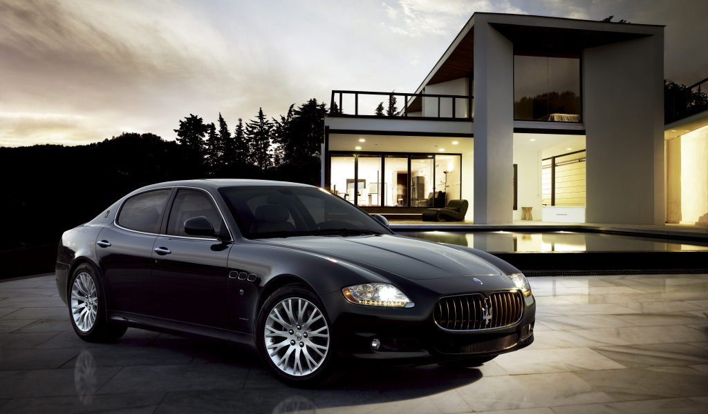 Черный автомобиль  Maserati Quattroporte у большого дома