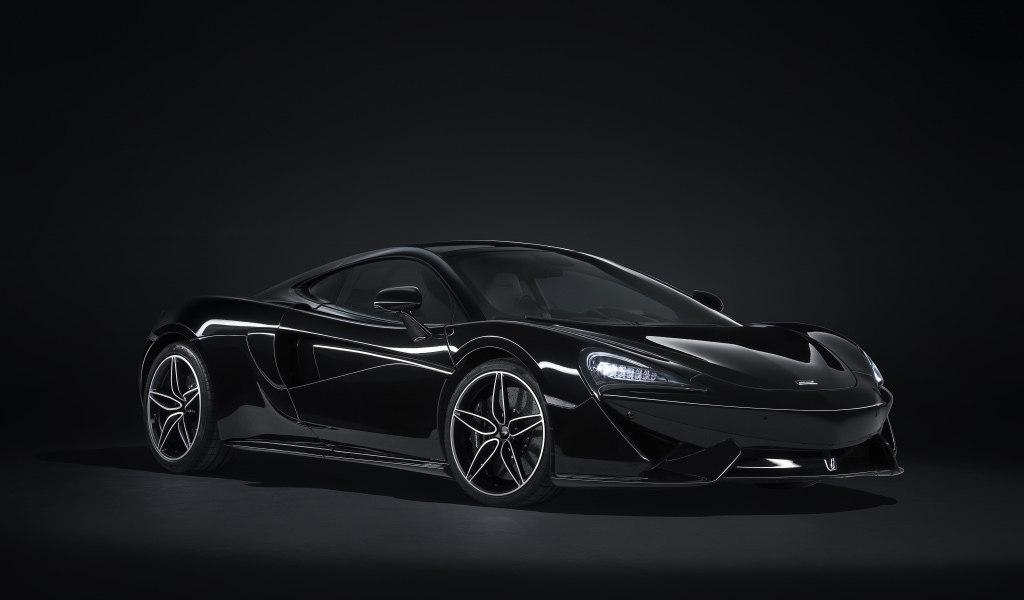 Черный автомобиль McLaren 570GT на сером фоне