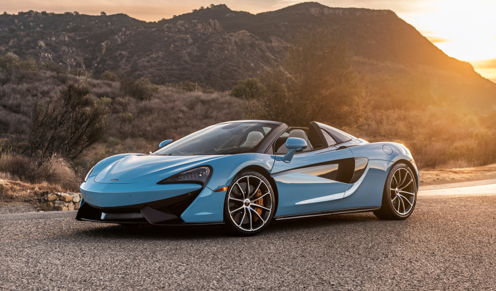 Голубой спортивный автомобиль  McLaren 570S Spider, 2018 на фоне солнца