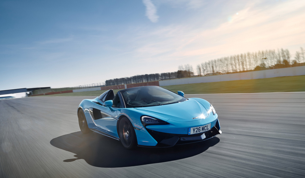 Голубой спортивный автомобиль McLaren 570S, 2018 года на трассе