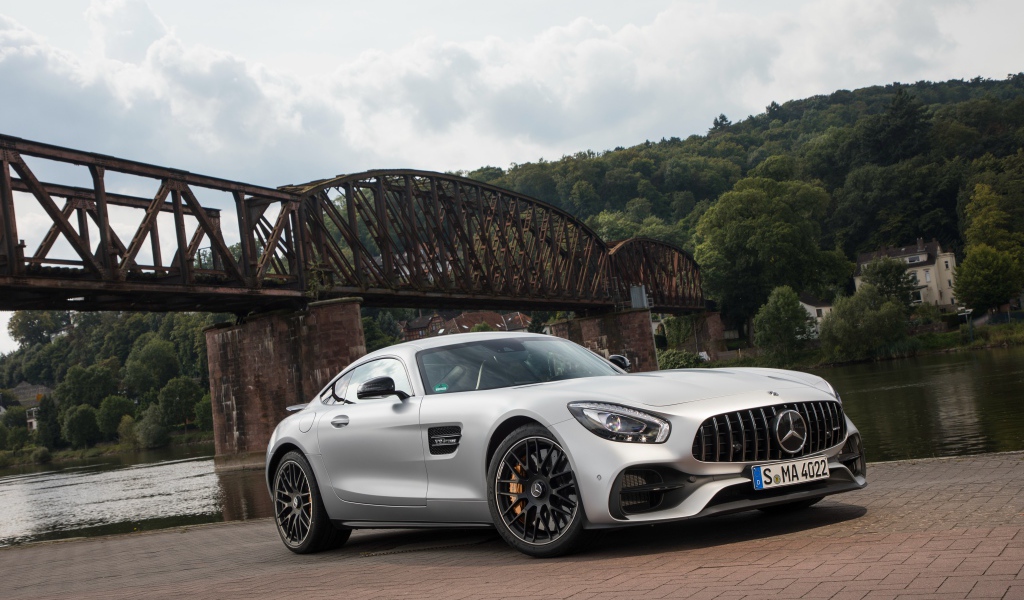 Серебристый автомобиль Mercedes-AMG GT на фоне моста