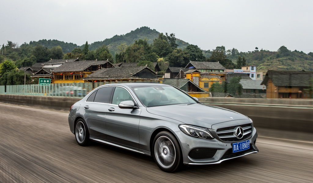 Серебристый автомобиль Mercedes-Benz C-Class на трассе