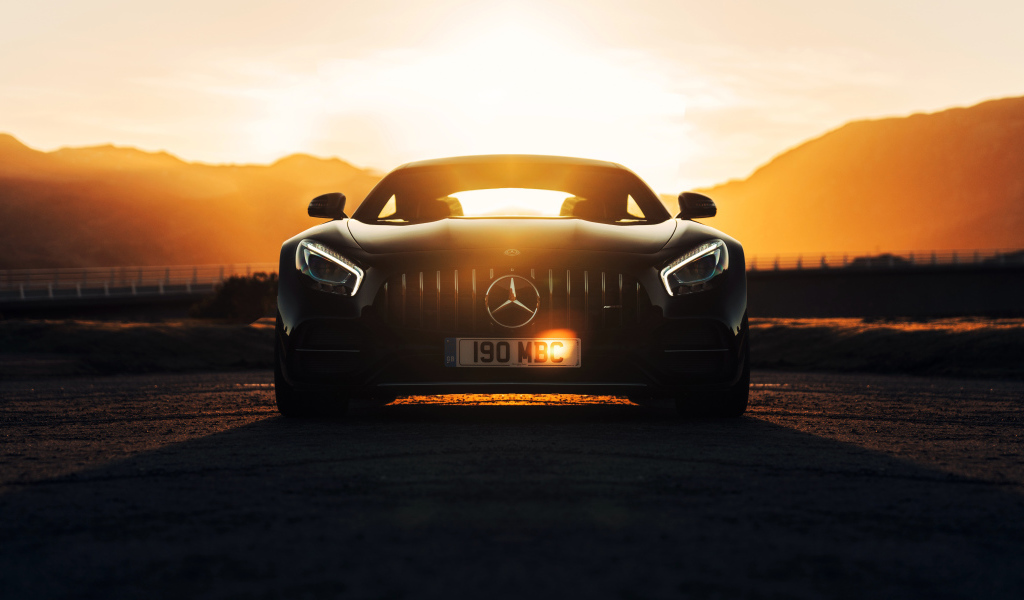 Стильный черный автомобиль Mercedes-AMG GT C на фоне заката