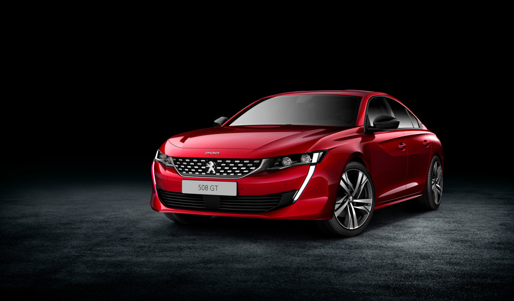 Красный стильный автомобиль Peugeot 508 GT на черном фоне