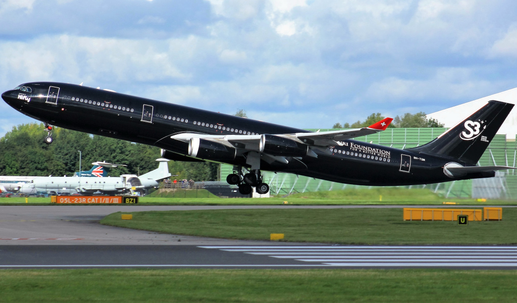Черный пассажирский самолет Airbus A340-313 на взлете