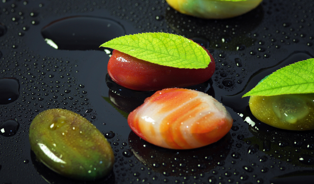 Красивые камни на черной мокрой поверхности