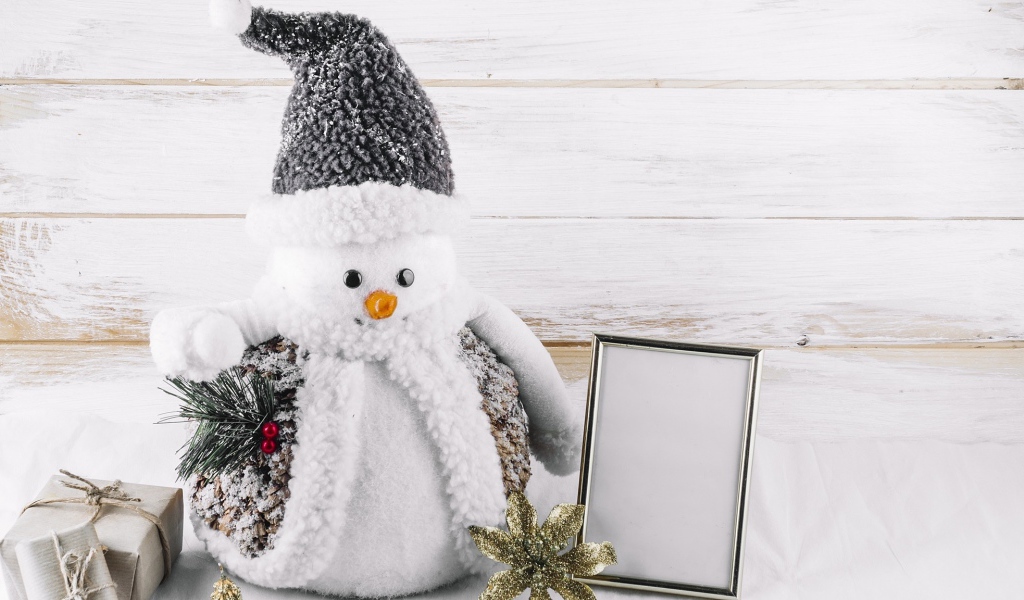 Большой игрушечный снеговик на деревянном фоне