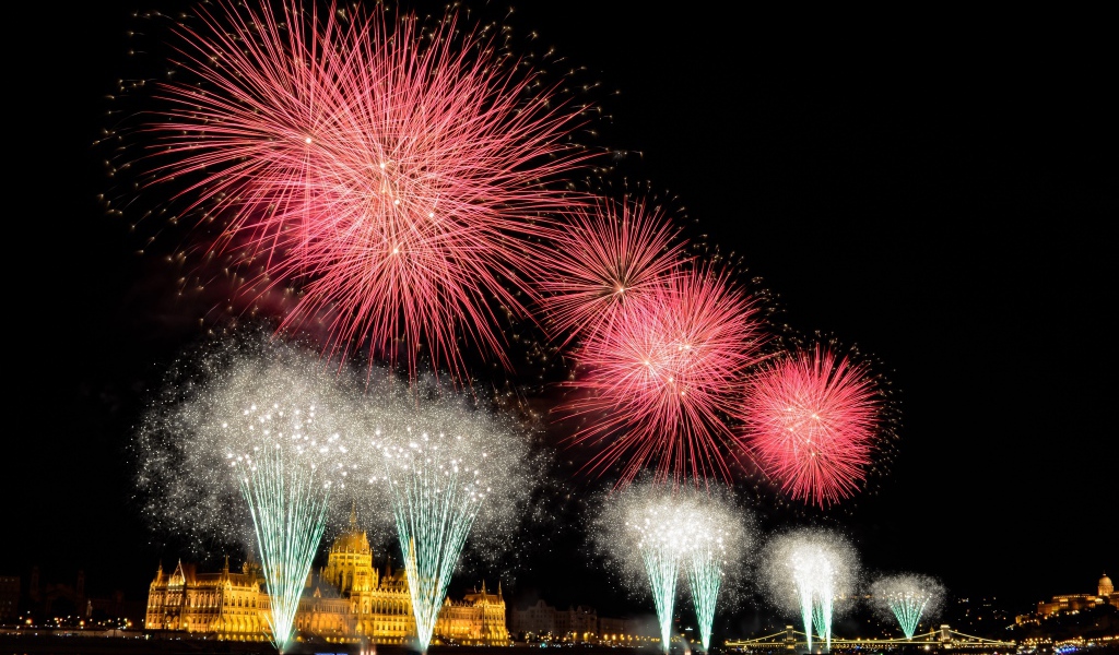 Взрывы яркого салюта над ночным городом 