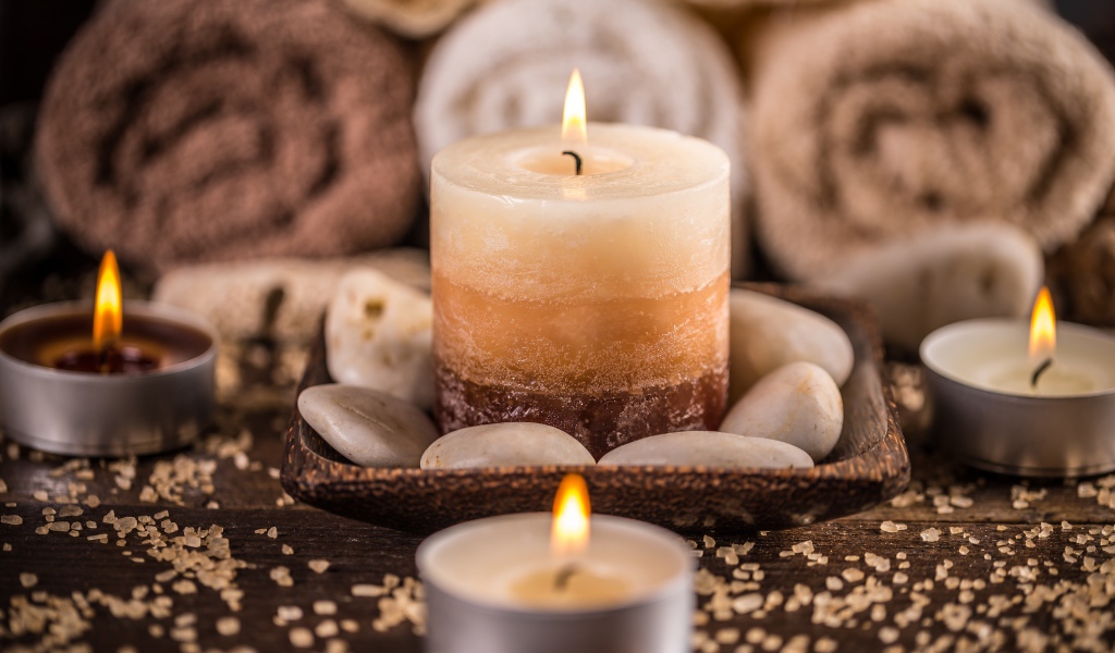 Зажженная свеча с камнями для SPA процедур