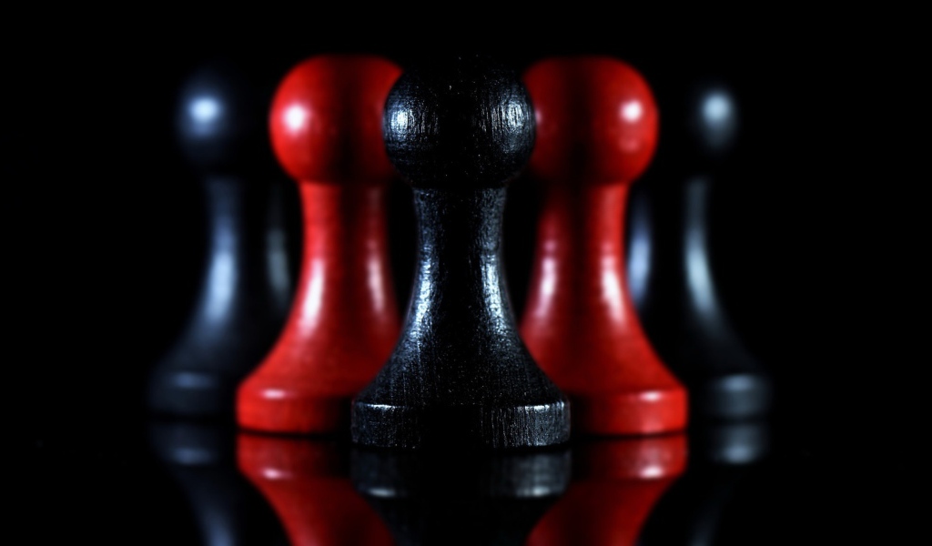 Красные и черные шахматные фигуры на черном фоне