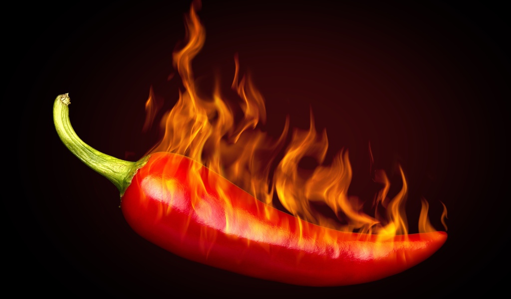 Красный перец с пламенем на черном фоне