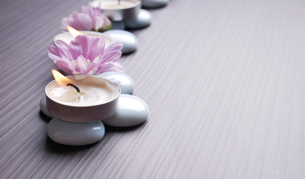 Камни с ароматическими свечами и цветами хризантемы