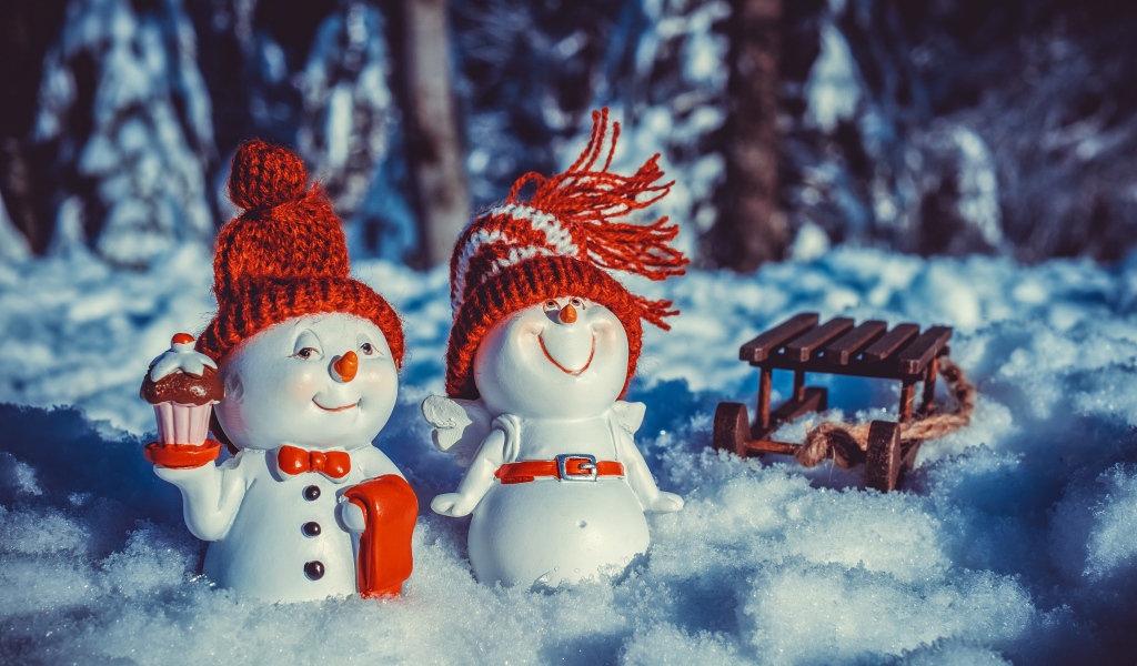 Две статуэтки снеговиков на снегу