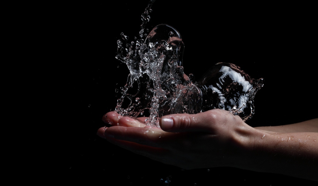 Вода в ладонях на черном фоне
