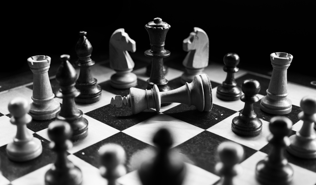 Деревянные шахматные фигуры на доске черно-белое фото